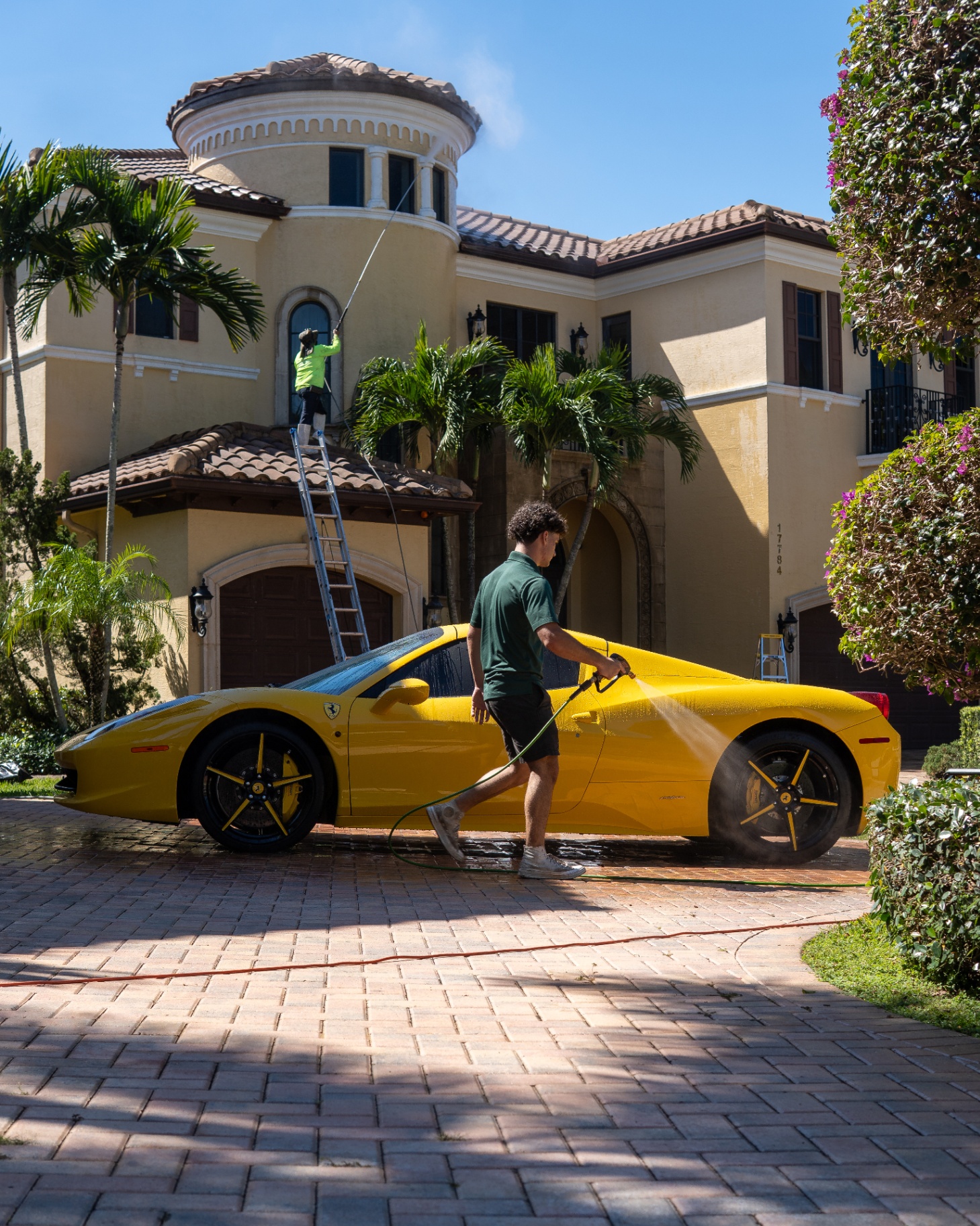 Lucky Luc detailing a yellow Ferrari 458 in a Plantation, FL driveway